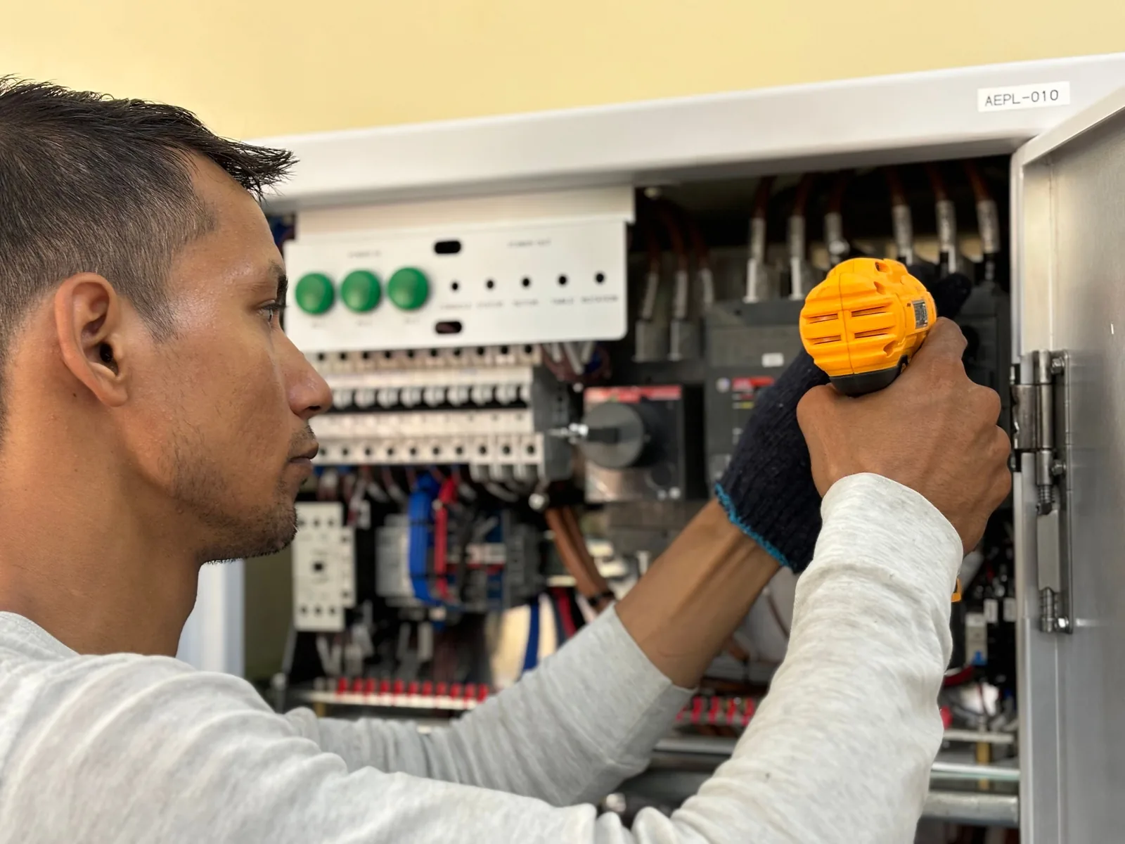 An electrician working on a commercial control panel, for panel upgrade in Detroit