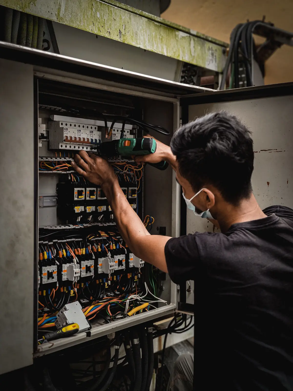 An electrician working inside a large distribution board, for panel upgrade in Detroit